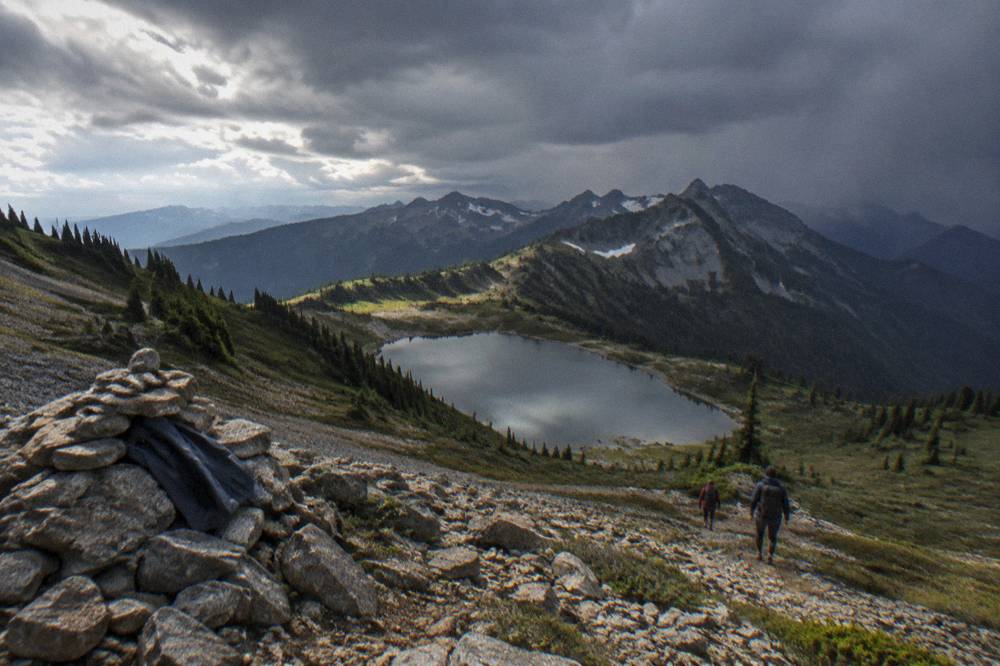 Rain clouds moving across an alpine ridge above a glacial lake basin