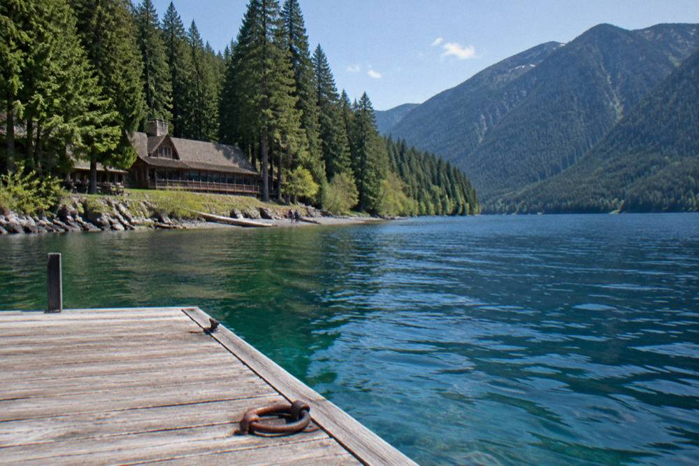 Clear blue lake surrounded by evergreen forest and steep hillsides