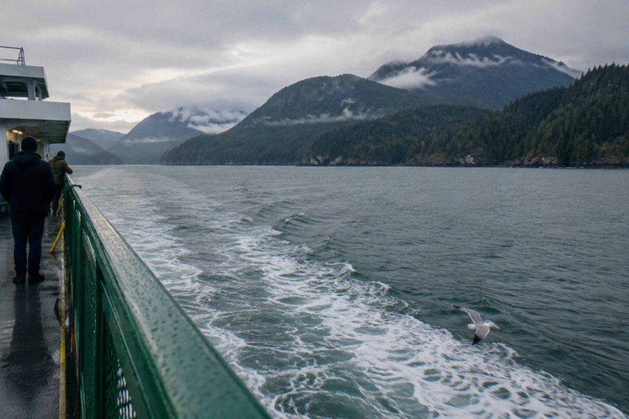 Washington State ferry crossing open water with forested mountains in the distance