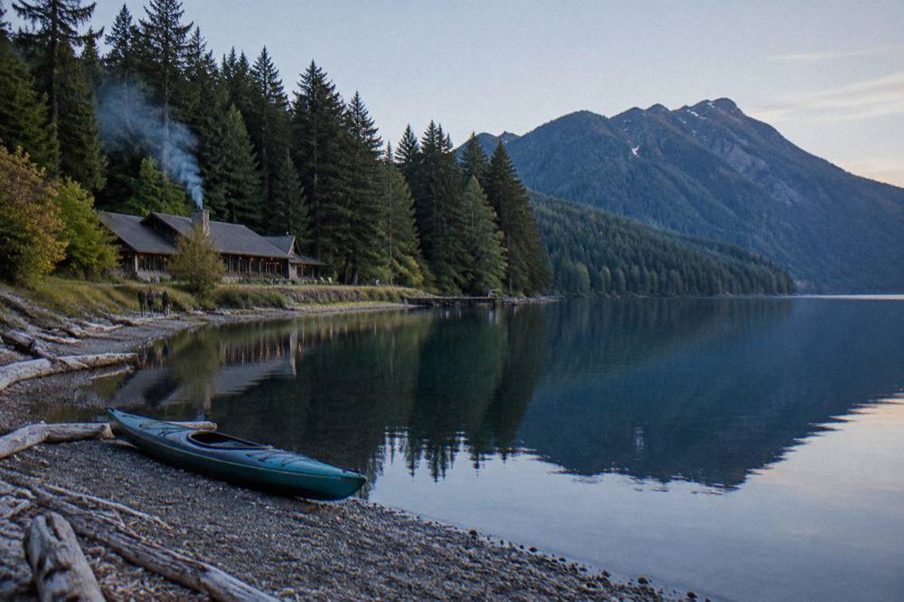 A calm blue mountain lake with forested slopes rising on both sides
