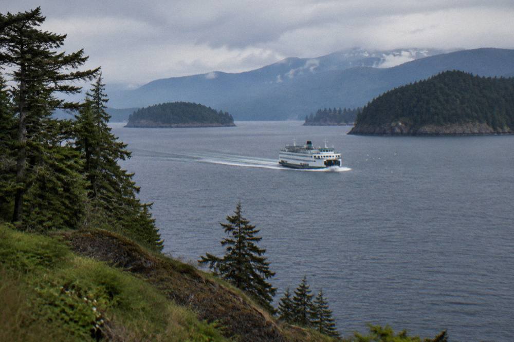 Washington State Ferry crossing Puget Sound with forested islands and distant mountains