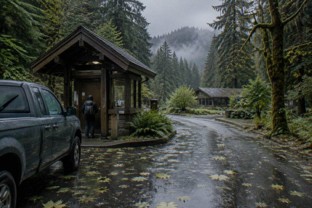Hiker holding a paper pass at a wooden entrance station window