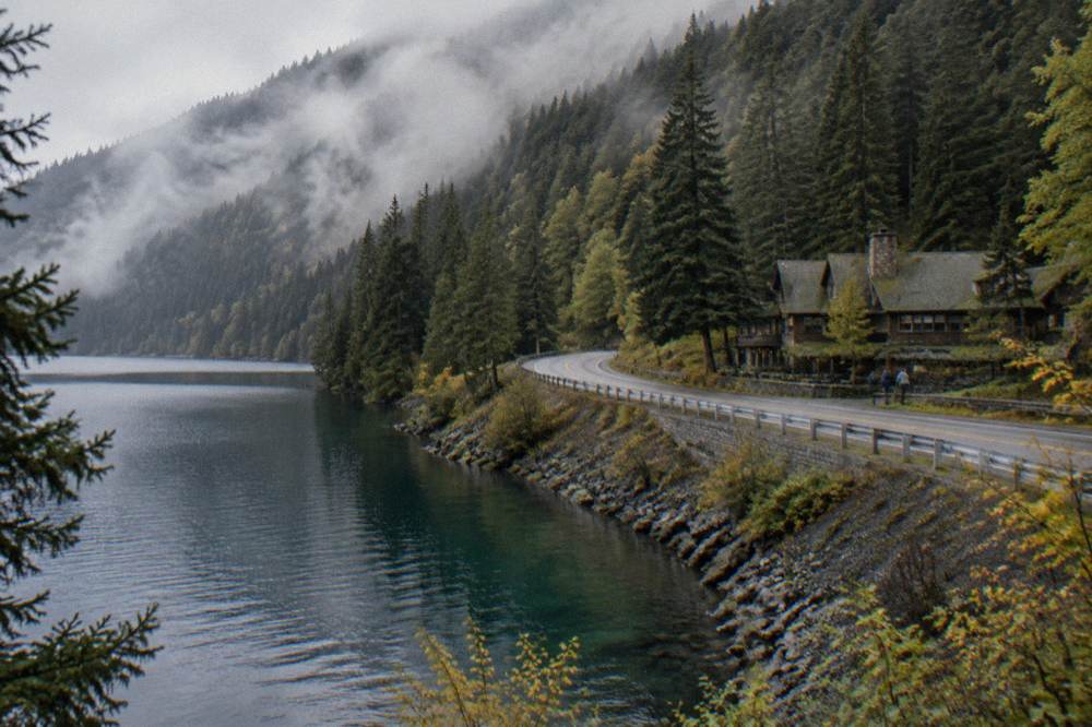 Highway curving along the forested shore of a glacial lake