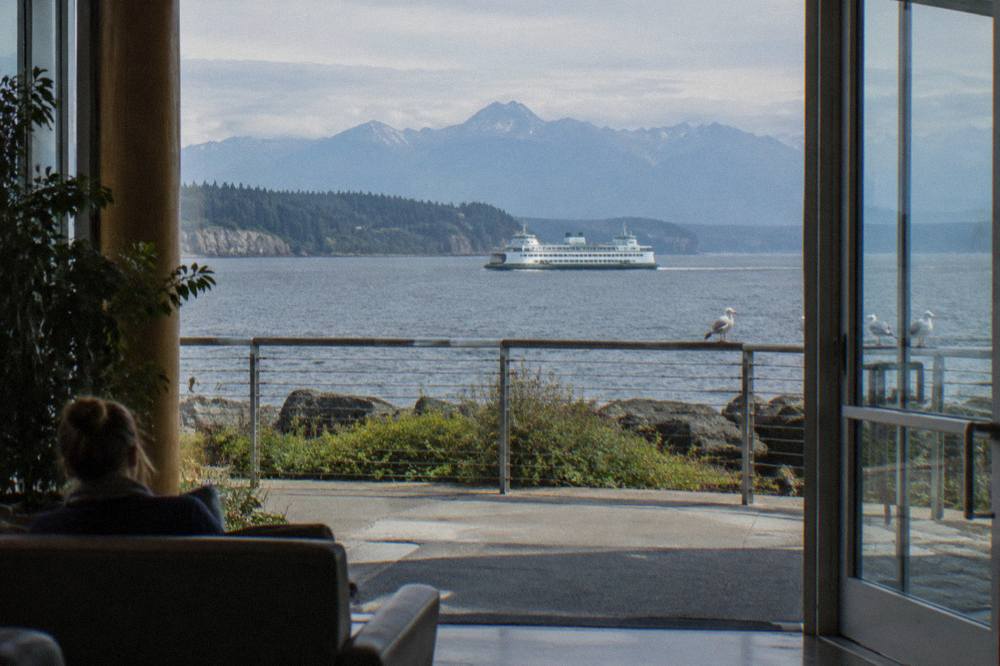 Ferry crossing open water with forested mountains in the distance