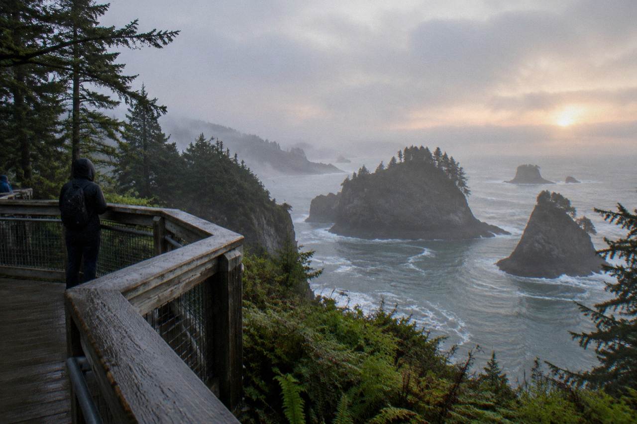 A quiet mountain overlook above evergreen ridges with morning haze in the valleys below